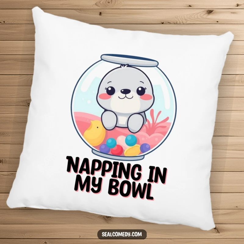 Funny pillow featuring a seal peeking from a colorful fishbowl, offering comfort and a touch of playful humor.