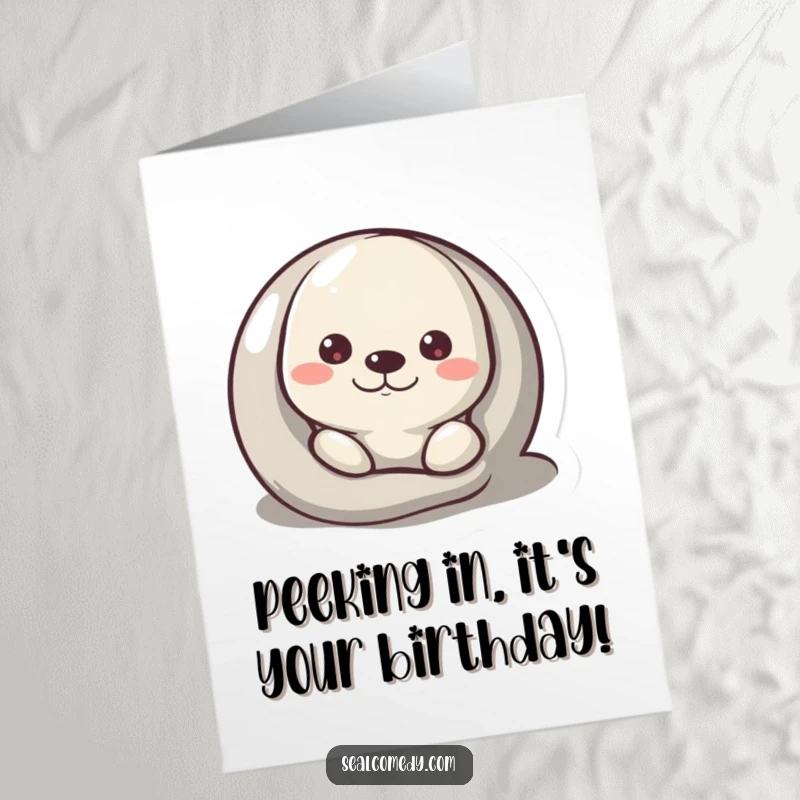 Funny Free Printable birthday card: A curious seal playfully peeks from behind a smooth pebble, wishing a happy birthday.